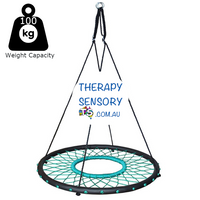 Web nest tire swing from TherapySensory.com.au shows a round padded circle with rope in a cobweb design that leaves a hole in the circle so you can drop your legs through. 4 ropes lead up to two metal circles that you can hang together to make the swing s