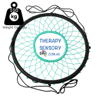 Web nest tire swing from TherapySensory.com.au shows a round padded circle with rope in a cobweb design that leaves a hole in the circle so you can drop your legs through. 4 ropes lead up to two metal circles that you can hang together to make the swing s